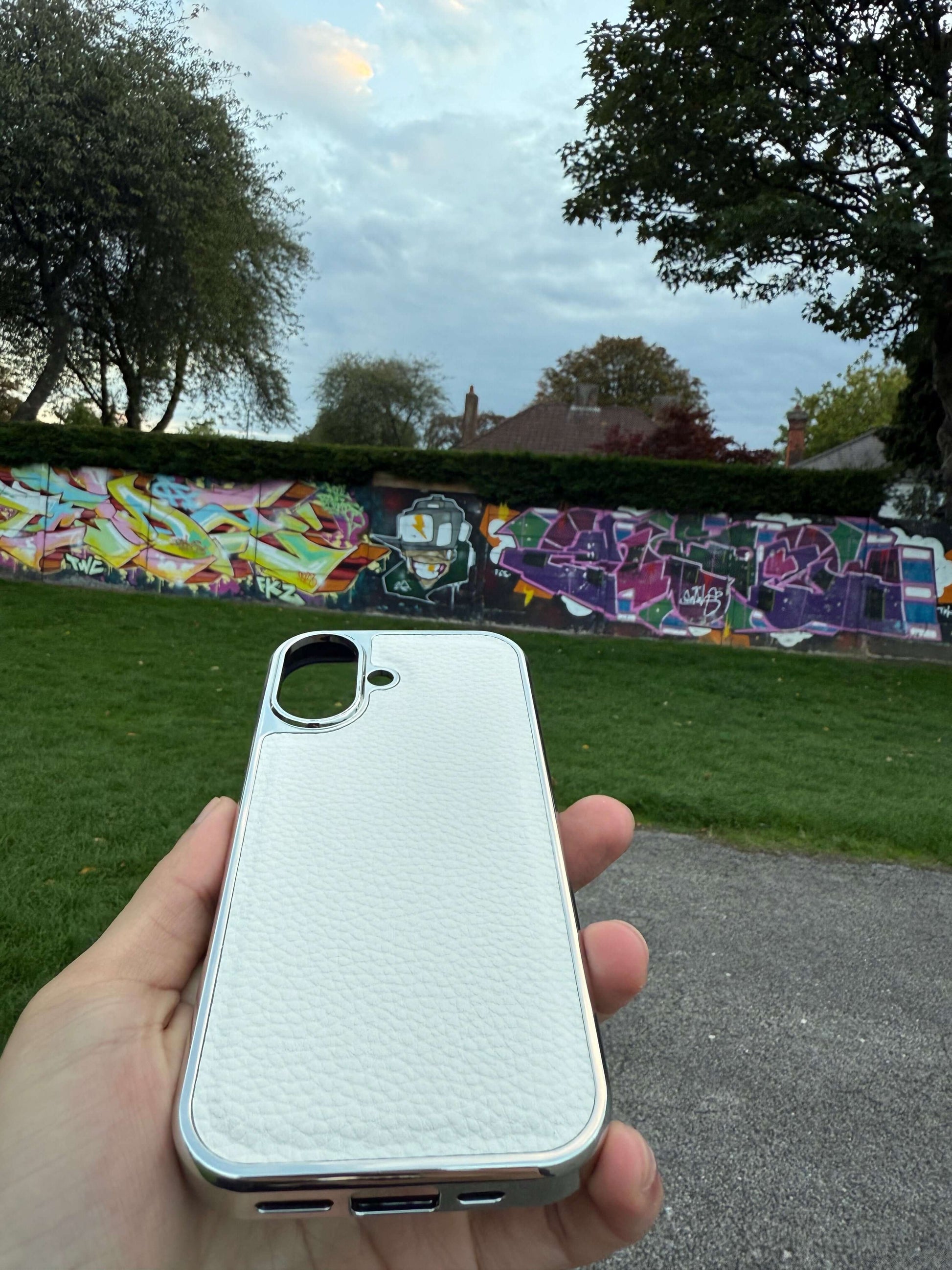 Premium Protection Kit iPhone 17 showcasing a handcrafted leather back case against vibrant graffiti.